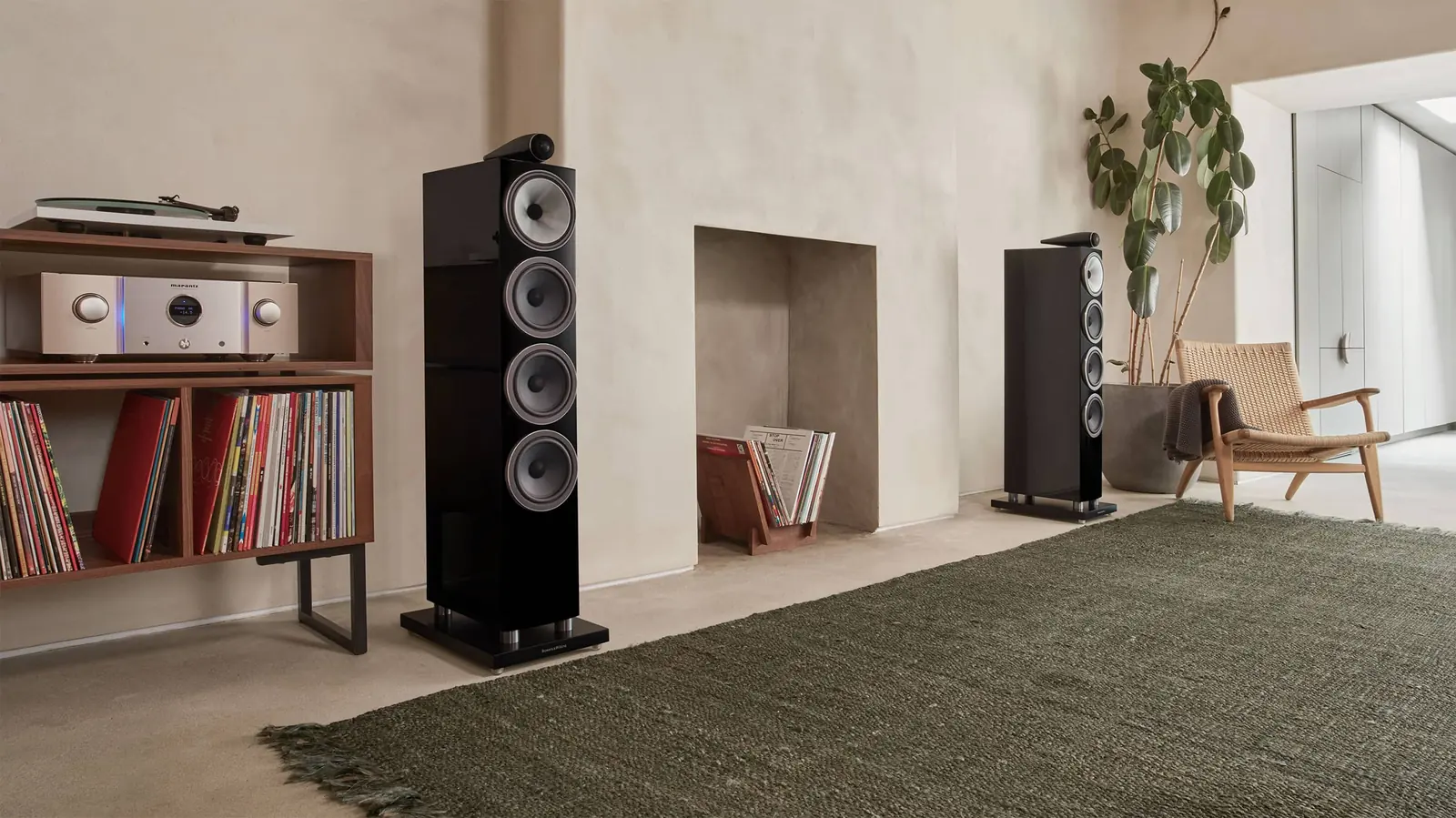 Par de Bowers & Wilkins 702 S3 en negro brillante en una sala con tocadiscos, amplificador y discos de vinilo